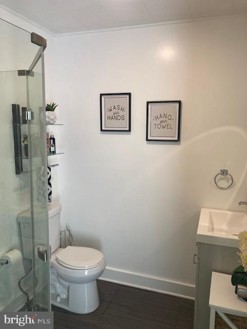 bathroom featuring vanity, toilet, and walk in shower