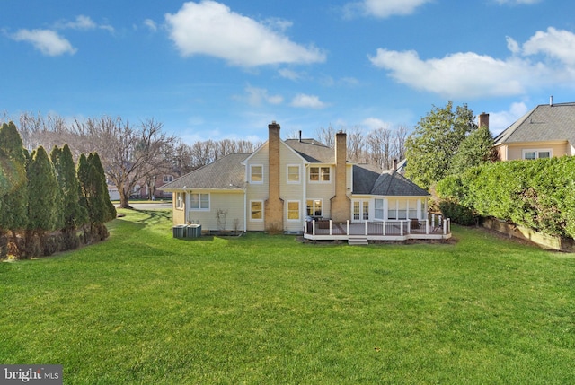 rear view of property with a wooden deck, a yard, and central AC unit