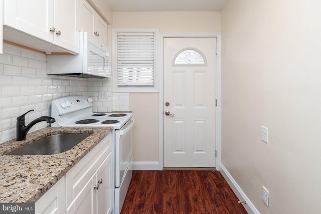 kitchen with sink, white appliances, light stone counters, white cabinets, and dark hardwood / wood-style flooring