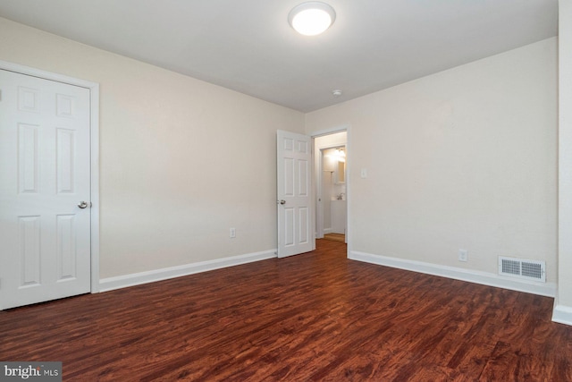 empty room with dark hardwood / wood-style flooring