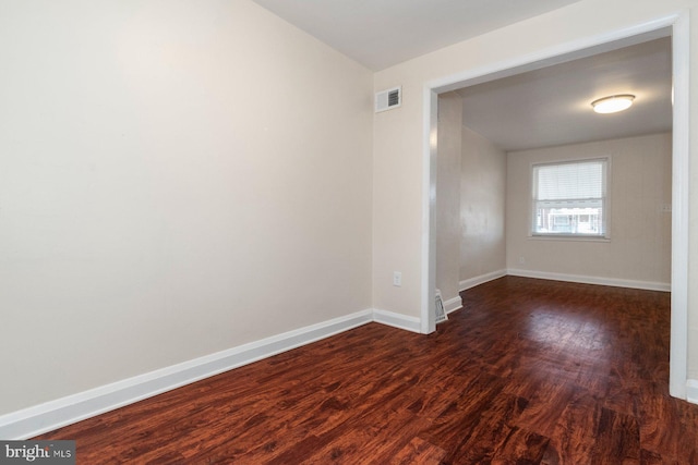 spare room featuring dark wood-type flooring