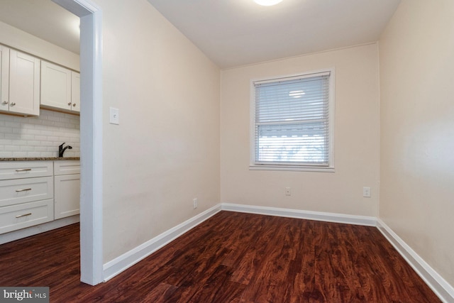 unfurnished room with sink and dark hardwood / wood-style floors