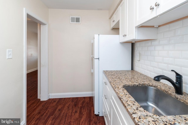 kitchen with white cabinetry, dark wood-type flooring, sink, and light stone counters