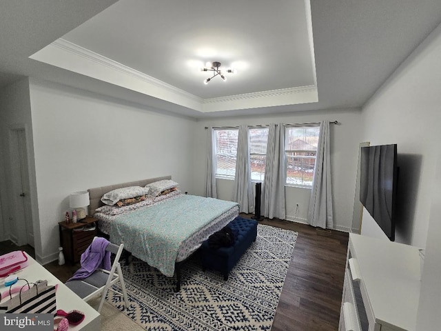 bedroom with a tray ceiling, ornamental molding, and dark hardwood / wood-style floors