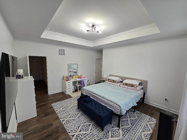 bedroom featuring dark hardwood / wood-style floors, ornamental molding, and a tray ceiling