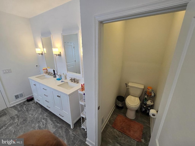 bathroom featuring vanity and toilet