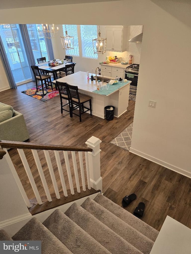 dining space featuring dark hardwood / wood-style floors, sink, and an inviting chandelier