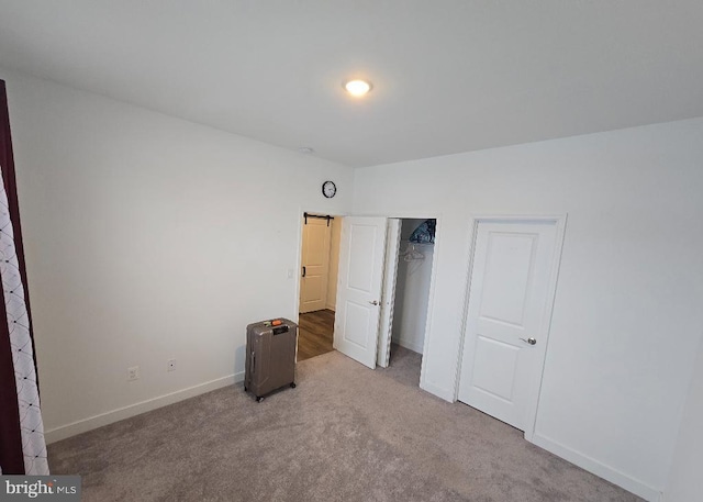 unfurnished bedroom featuring light colored carpet and a closet