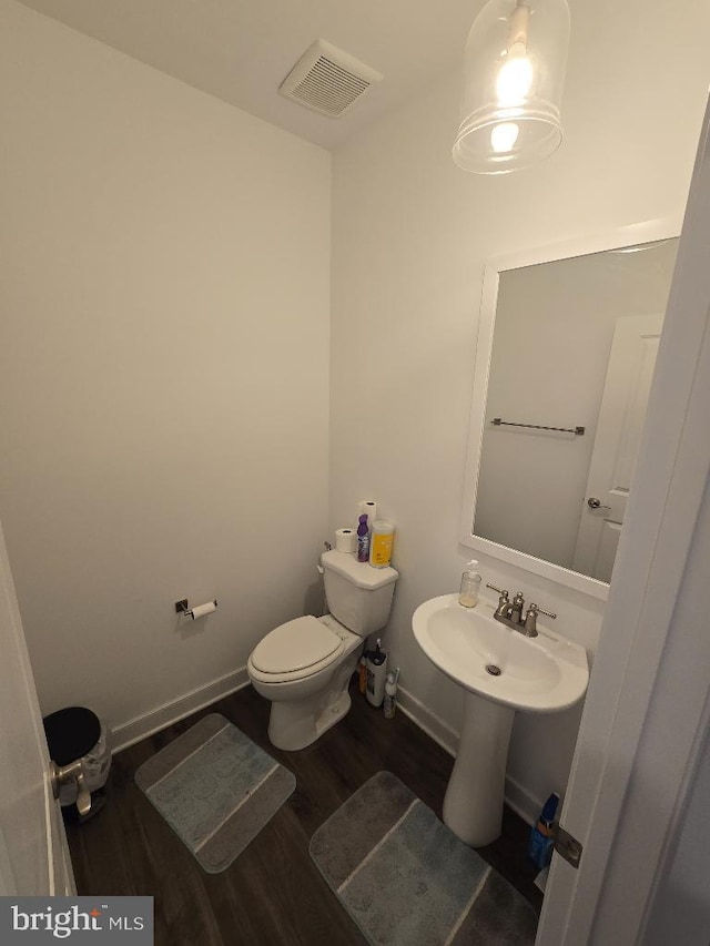 bathroom with wood-type flooring and toilet