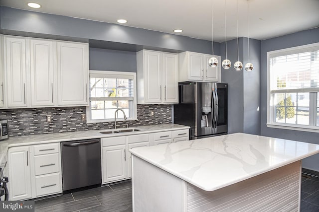 kitchen featuring white cabinetry, appliances with stainless steel finishes, sink, and a kitchen island