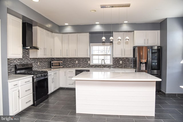 kitchen with a kitchen island, white cabinets, hanging light fixtures, stainless steel appliances, and wall chimney range hood