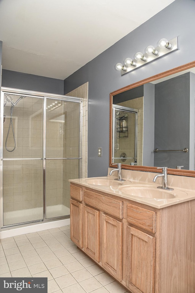 bathroom with an enclosed shower, vanity, and tile patterned flooring