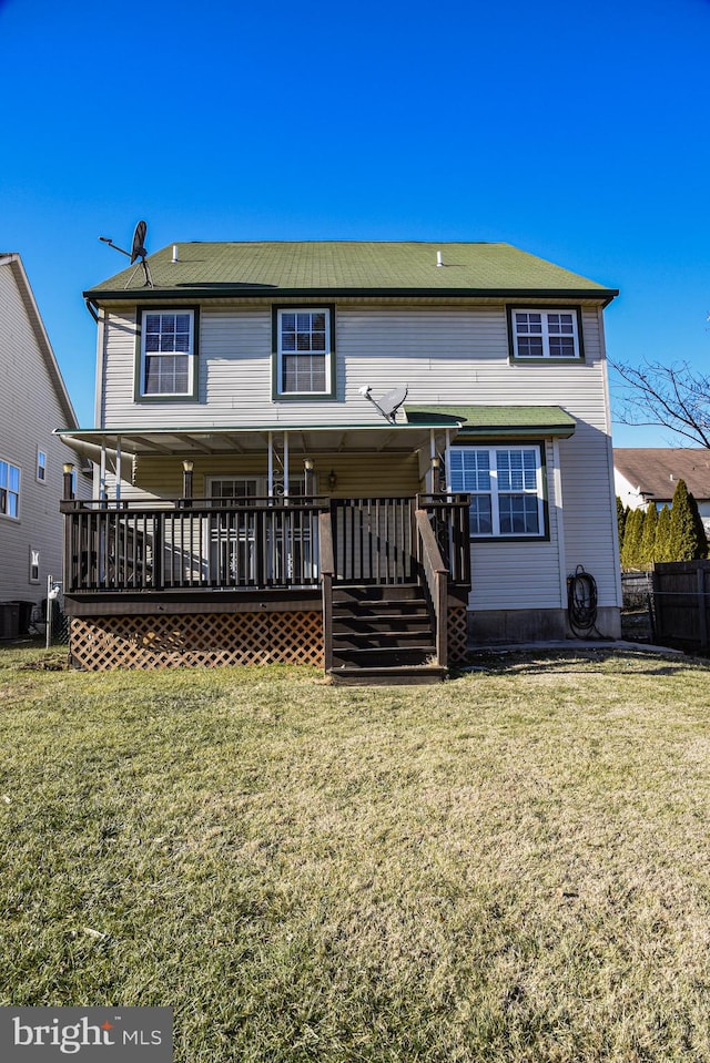 rear view of house featuring a deck and a lawn