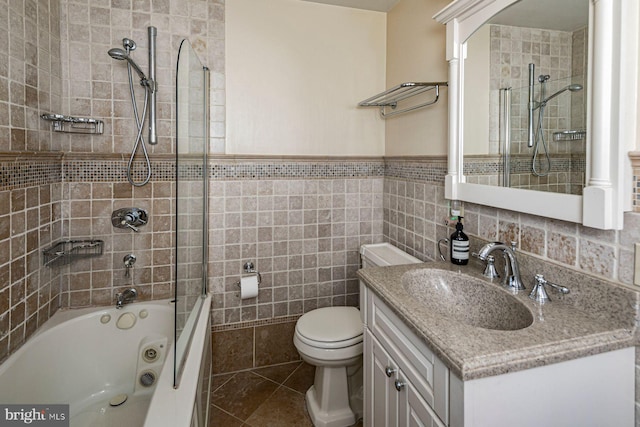 full bathroom with toilet, bathtub / shower combination, vanity, and tile walls