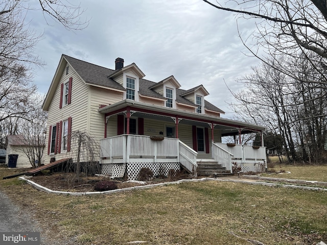 view of front facade with a porch, a front yard, and a shingled roof