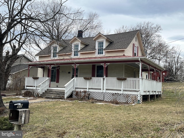 view of front facade featuring covered porch, roof with shingles, and a front yard