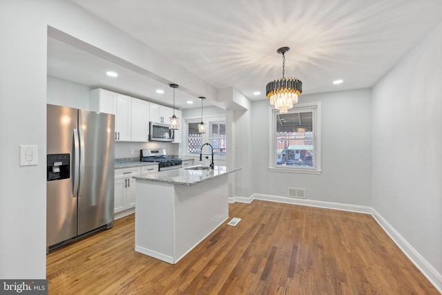 kitchen featuring white cabinetry, sink, stainless steel appliances, and hanging light fixtures