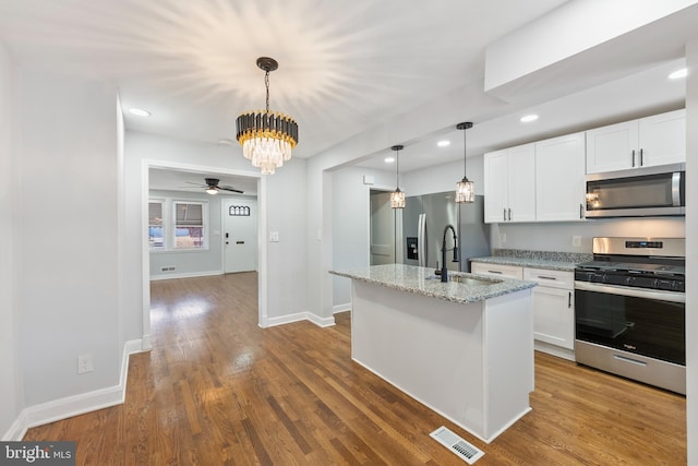 kitchen featuring white cabinetry, sink, light stone countertops, and appliances with stainless steel finishes