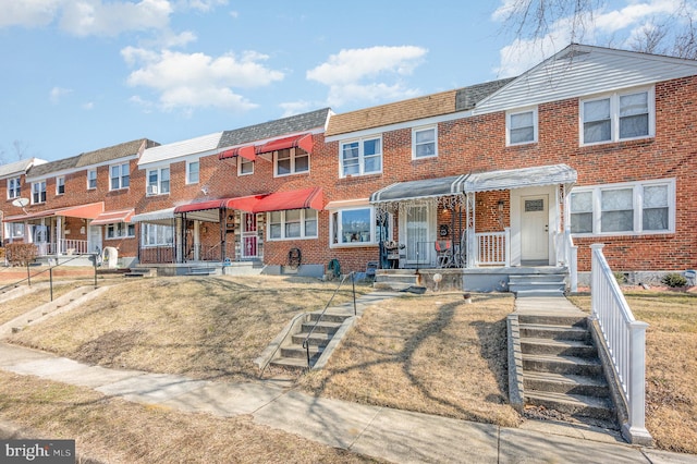 multi unit property with a porch and a front yard