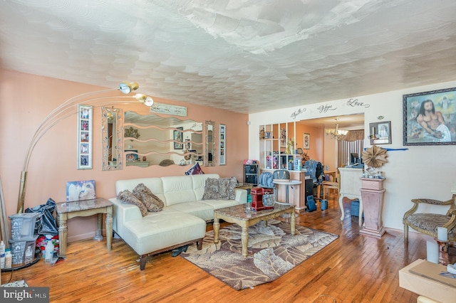 living room with hardwood / wood-style flooring, a textured ceiling, and a chandelier