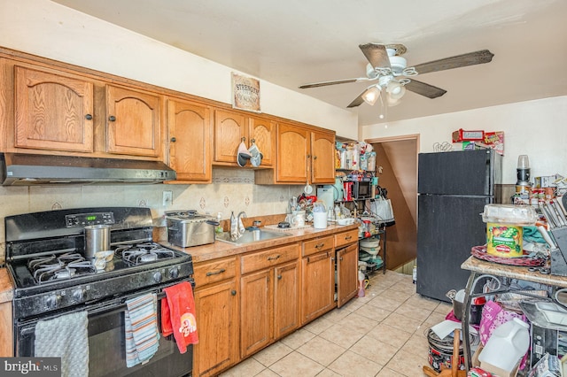 kitchen with light tile patterned flooring, sink, ceiling fan, decorative backsplash, and black appliances