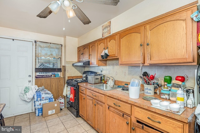 kitchen with light tile patterned flooring, tasteful backsplash, sink, ceiling fan, and black range with gas cooktop