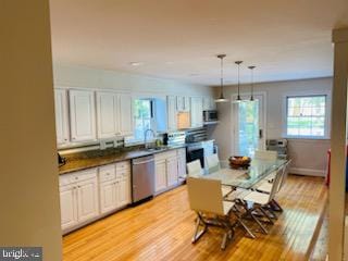 kitchen featuring pendant lighting, sink, appliances with stainless steel finishes, light hardwood / wood-style floors, and white cabinets