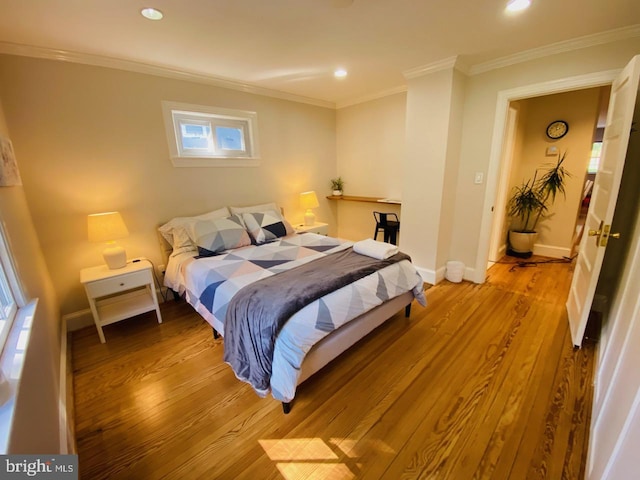 bedroom featuring multiple windows, ornamental molding, and light hardwood / wood-style floors