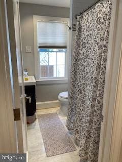 bathroom featuring vanity, toilet, and walk in shower