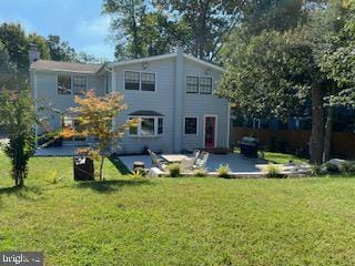 back of property featuring a yard and a patio