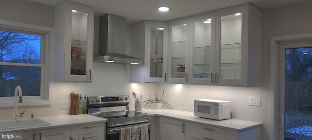 kitchen with white cabinetry, sink, wall chimney exhaust hood, and stainless steel electric range oven