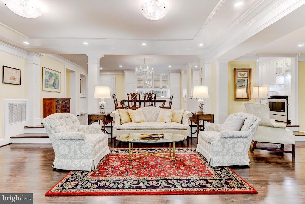 living room with crown molding, decorative columns, and dark hardwood / wood-style floors