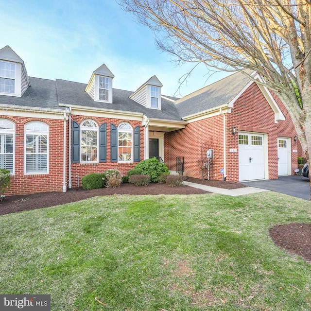 view of front of home featuring a front yard, a garage, brick siding, and driveway