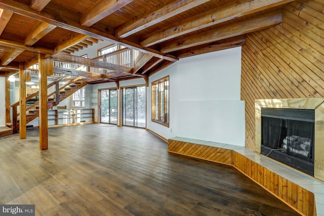 unfurnished living room featuring hardwood / wood-style floors, a fireplace, vaulted ceiling with beams, and wooden ceiling