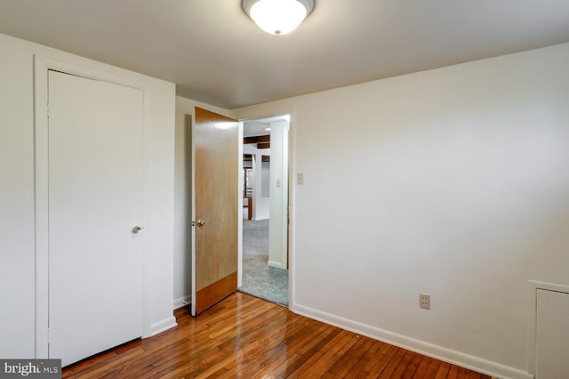 unfurnished bedroom featuring wood-type flooring and a closet