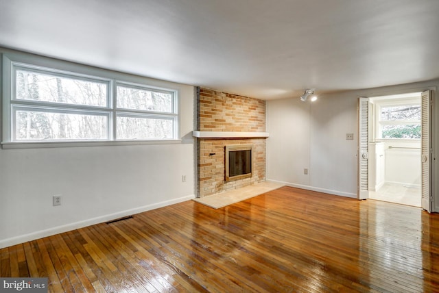 unfurnished living room featuring hardwood / wood-style flooring and a fireplace