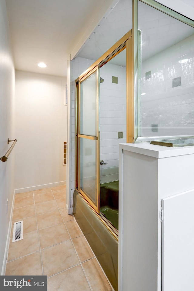 bathroom with tile patterned flooring and combined bath / shower with glass door