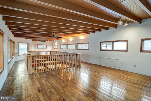 unfurnished room with beamed ceiling, light hardwood / wood-style floors, and wooden ceiling