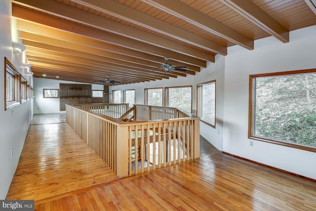 corridor featuring light hardwood / wood-style floors, wooden ceiling, and beamed ceiling