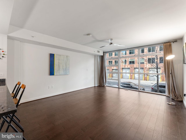 unfurnished living room with dark wood-type flooring, ceiling fan, and floor to ceiling windows