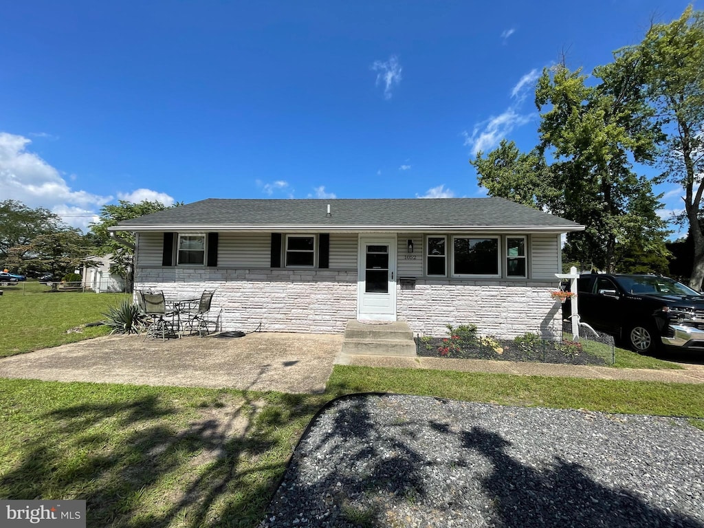 single story home featuring a front yard and a patio area