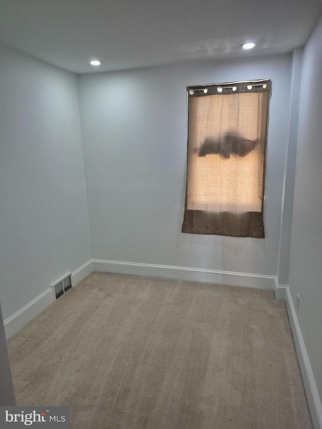 empty room featuring carpet floors, recessed lighting, visible vents, and baseboards