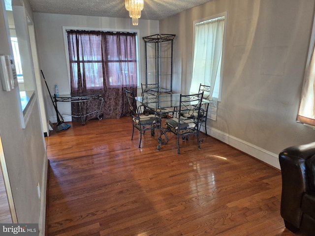 dining space featuring a textured ceiling, wood finished floors, and a healthy amount of sunlight