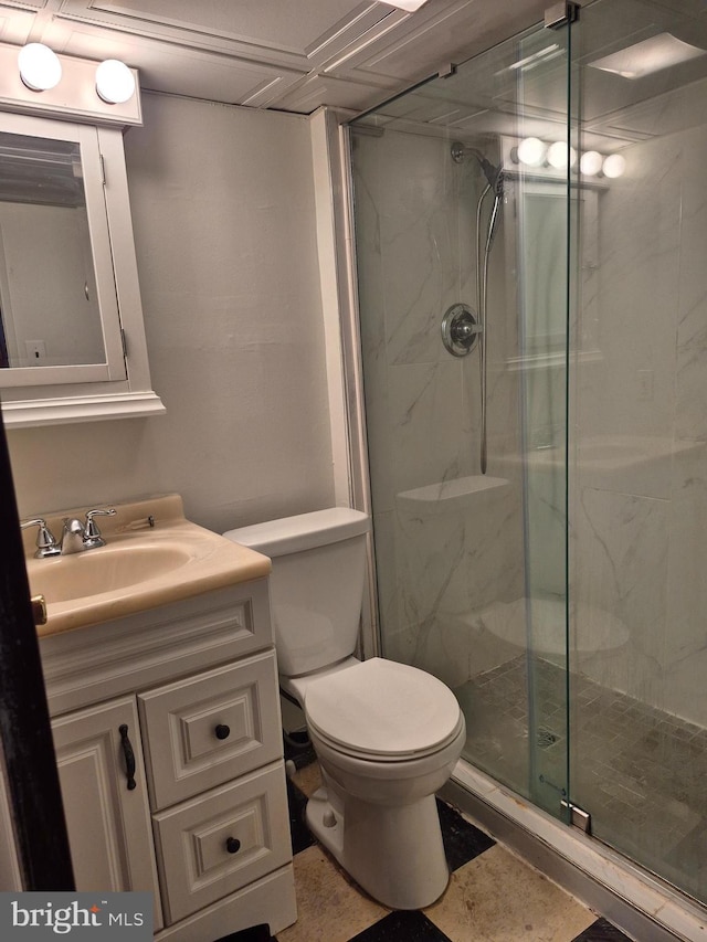 bathroom with toilet, a marble finish shower, and vanity