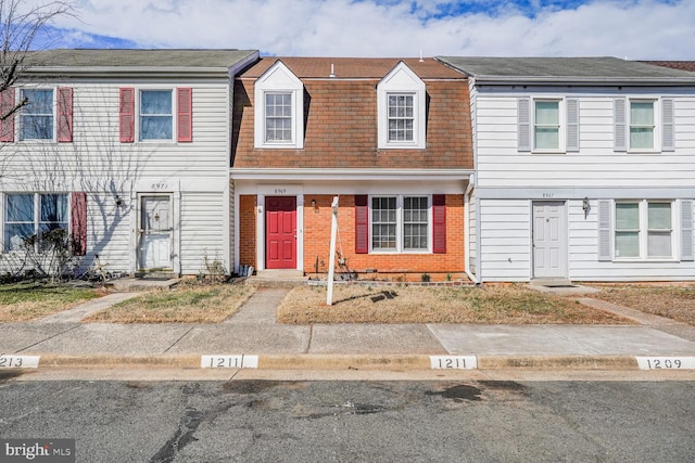 townhome / multi-family property featuring brick siding and a shingled roof