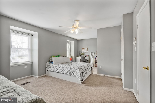 carpeted bedroom with visible vents, ceiling fan, and baseboards