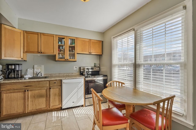 kitchen featuring electric stove, a sink, white dishwasher, light countertops, and glass insert cabinets