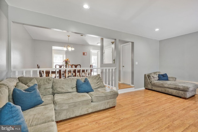 living room featuring a notable chandelier, recessed lighting, and wood finished floors