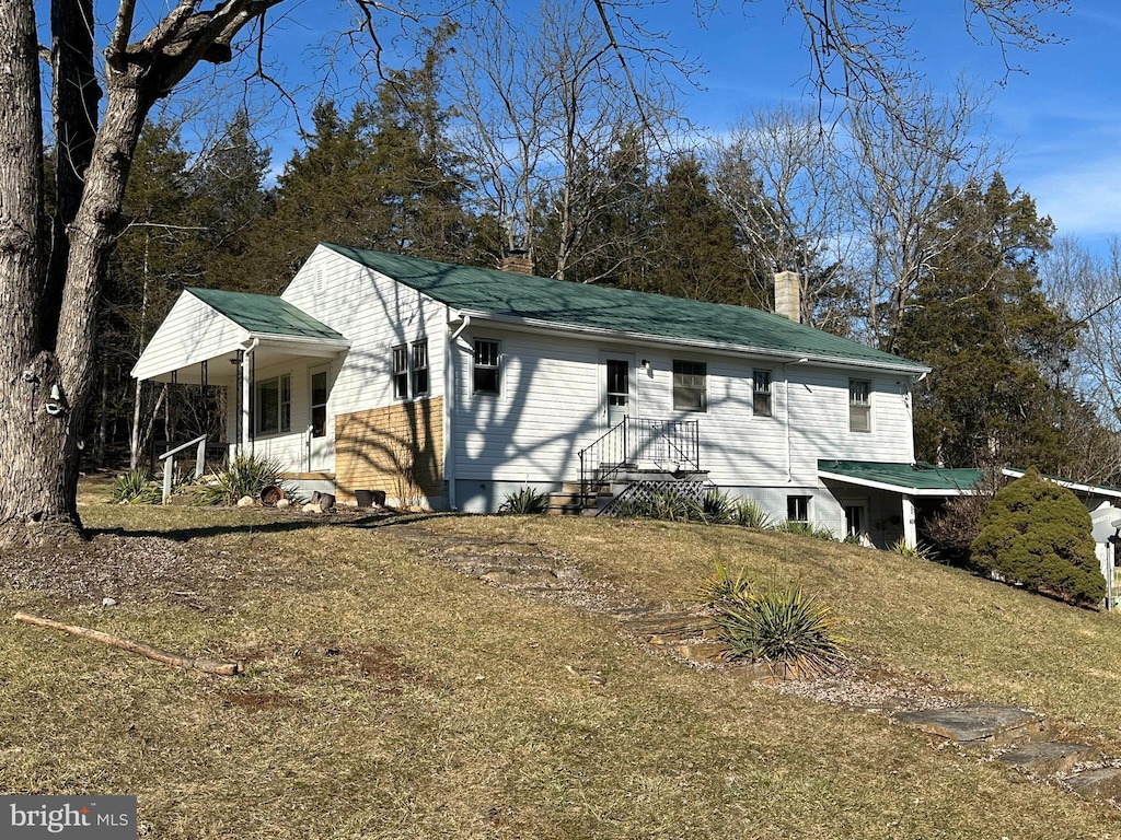 view of side of property with a yard and covered porch