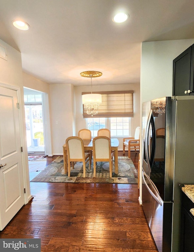 dining area featuring dark hardwood / wood-style floors and an inviting chandelier